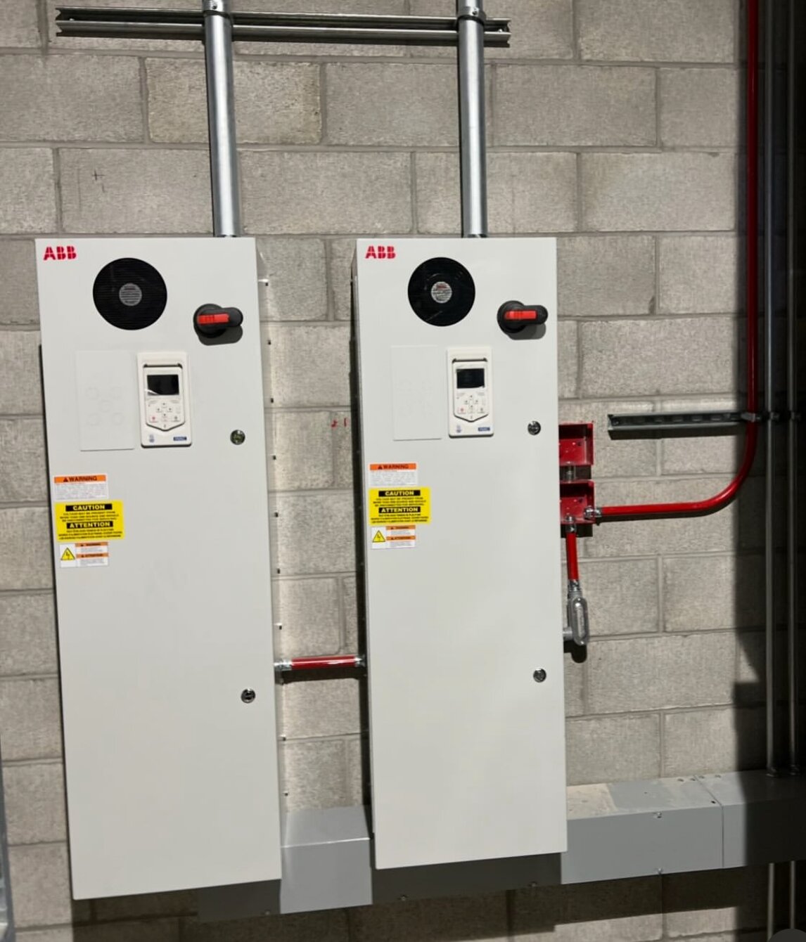 Commercial ABB motor drives mounted on a block wall